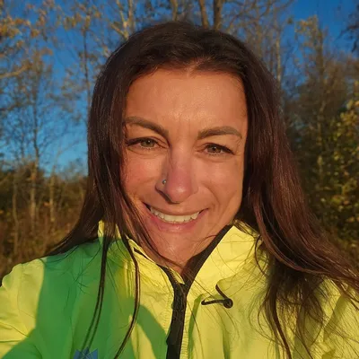 Lori Schmidt smiling, seated cross-legged — trauma-informed yoga teacher in Thunder Bay