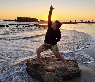 Lori in supported fish pose at sunset on a Lake Superior shoreline